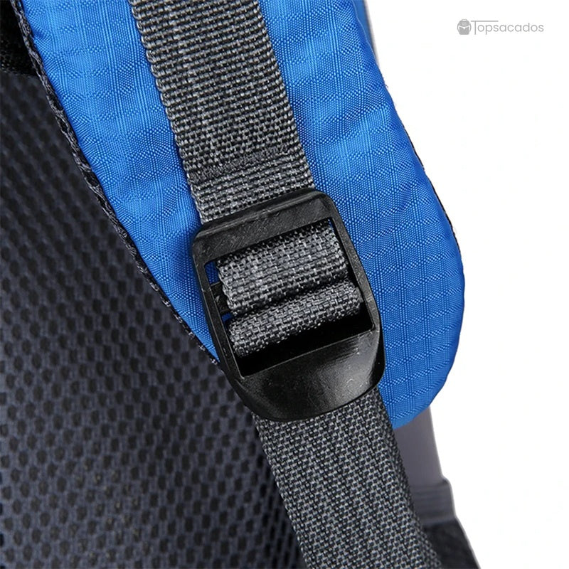 Sac à dos 40L randonnée gros plan sur le réglage des sangles au niveau de l'épaule, tissu bleu et sangle noire