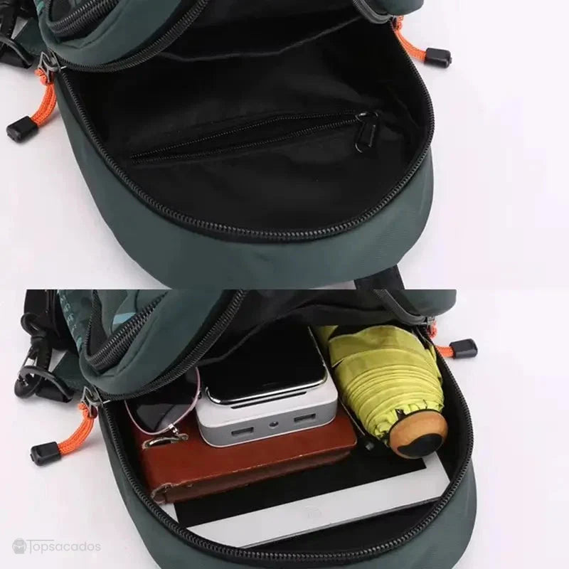 Petit Sac à dos vert ouvert montrant son intérieur spacieux avec tablette, parapluie plié et accessoires électroniques sur fond blanc