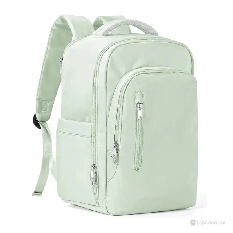 Sac à dos 40x20x25 vert pastel avec grande poche frontale, poches latérales et bretelles larges, posé en studio sur fond blanc.