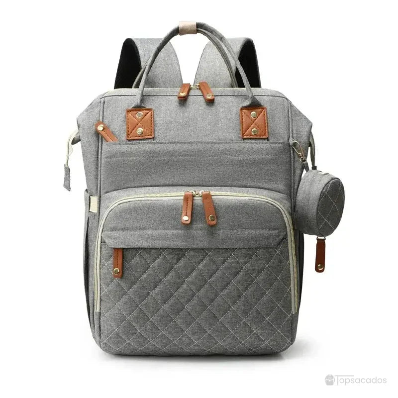 Sac à dos à langer avec port usb en tissu gris clair, présenté verticalement de face avec poche zippée matelassée et trousse latérale assortie, sur fond blanc.
