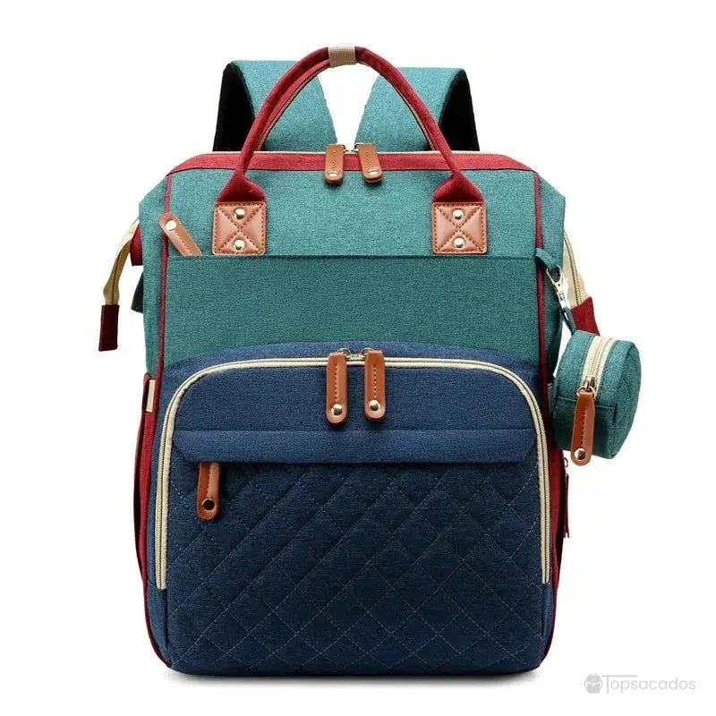 Sac à dos à langer avec port usb bicolore vert et bleu, design original avec détails rouges et poche isotherme assortie, sur fond blanc.