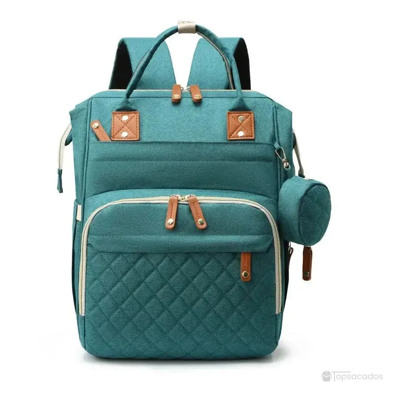 Sac à dos à langer avec port usb en tissu vert turquoise, finition élégante avec anses renforcées et grande poche frontale, sur fond blanc.