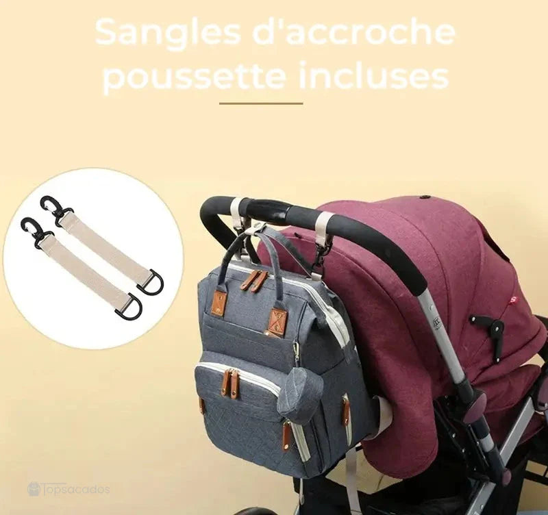Sac à dos à langer avec port usb suspendu à une poussette grâce aux sangles fournies, sur fond beige avec vue produit et zoom sur les crochets.