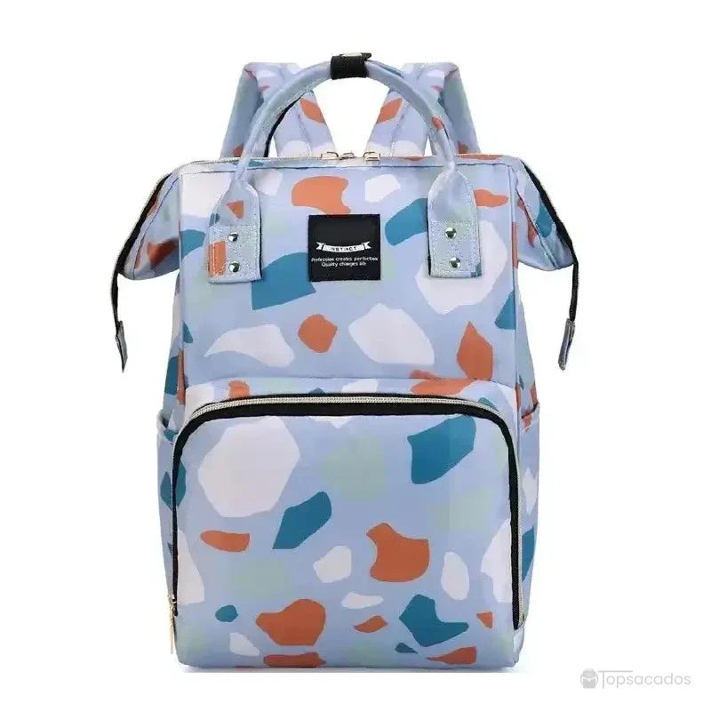 Sac à dos à langer bleu multicolore avec imprimé abstrait façon terrazzo dans des tons pastel, large poche avant zippée et anses renforcées, présenté sur fond blanc neutre.