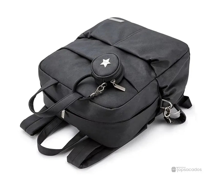 Sac à dos à langer élégant noir vu à plat, bretelles positionnées en arrière-plan, sur fond blanc