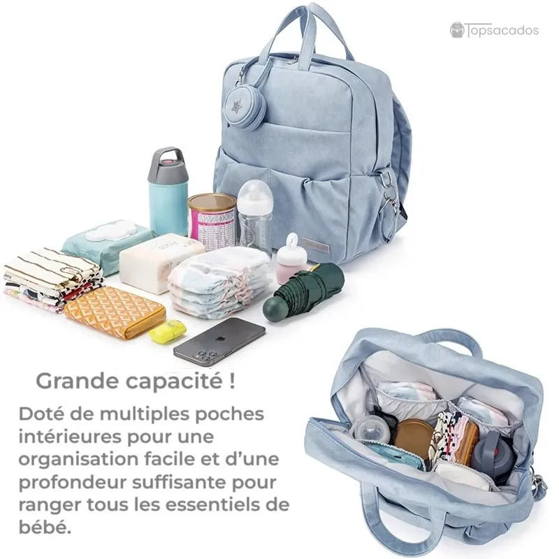Sac à dos à langer élégant bleu clair avec son contenu bébé étalé devant et compartiment interne visible