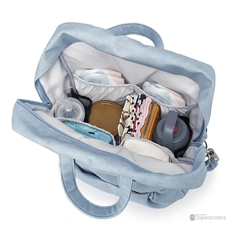 Sac à dos à langer élégant bleu clair ouvert et rempli d’accessoires bébé bien organisés