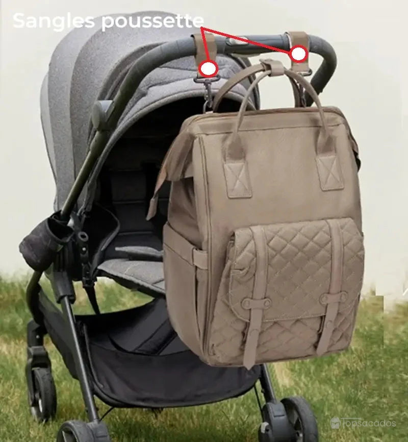 Sac à dos à langer multifonctions suspendu à une poussette grâce à des sangles dédiées, illustrant la praticité pour les sorties avec bébé.