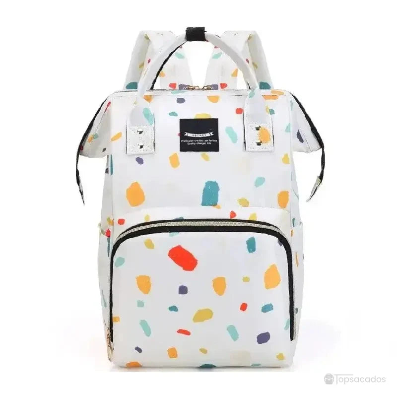 Sac à dos à langer blanc à motif éclaboussure multicolore dans des teintes orange, turquoise, jaune et violet, avec fermeture zippée et structure carrée rigide, sur fond clair sans décor.