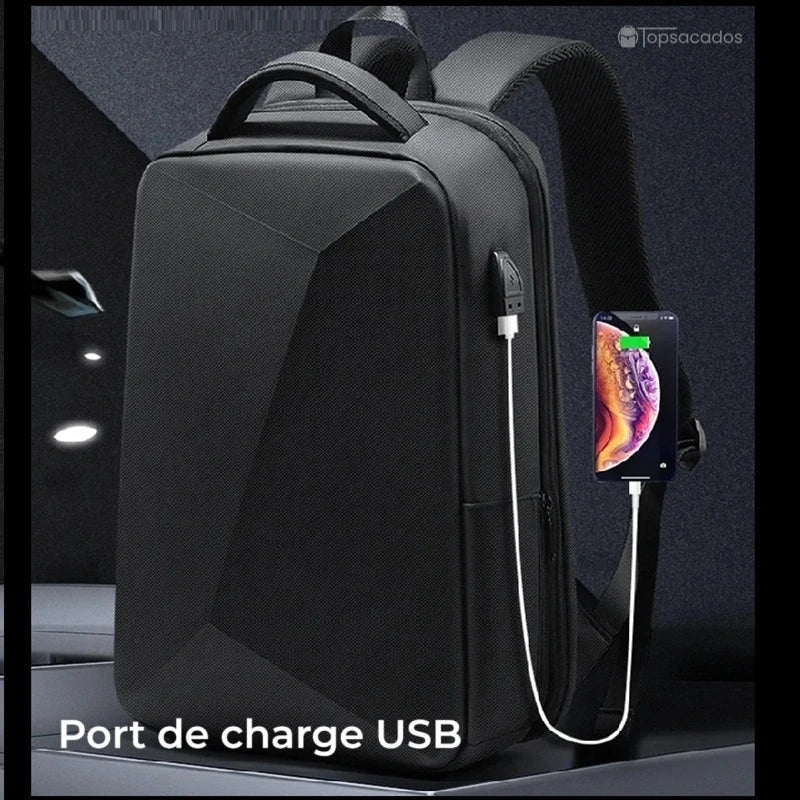 Sac à dos business en ABS avec port de charge USB connecté à un smartphone, posé sur un bureau en environnement sombre.
