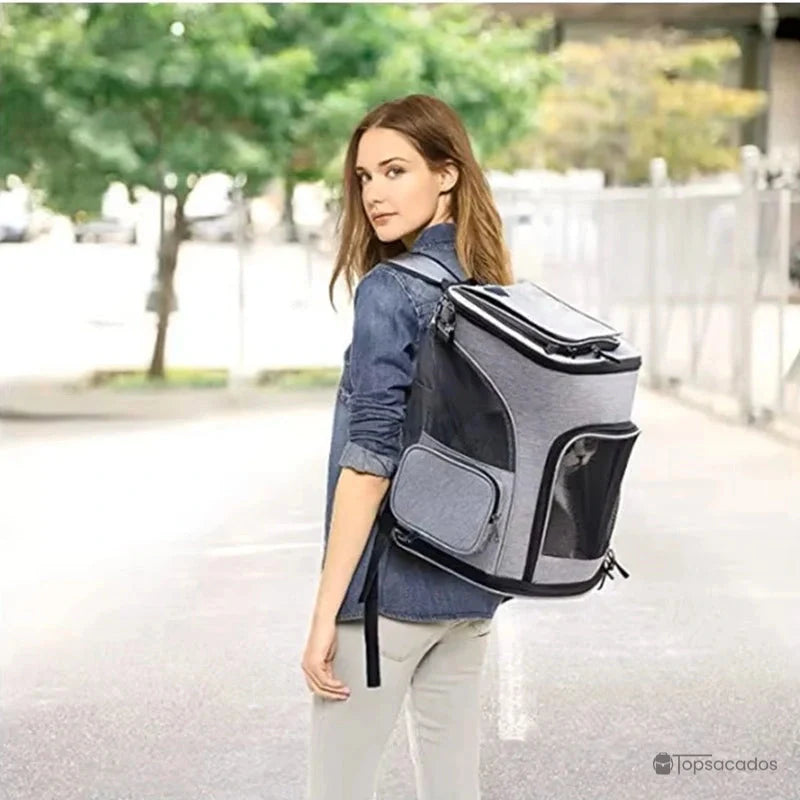 Sac à dos chat pliable porté par une femme dans la rue, avec un chat visible à l’intérieur à travers la maille frontale