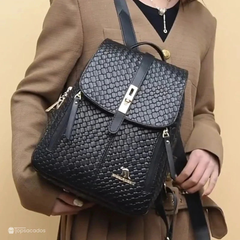 Sac à dos cuir femme noir porté à l’épaule par une femme élégamment habillée