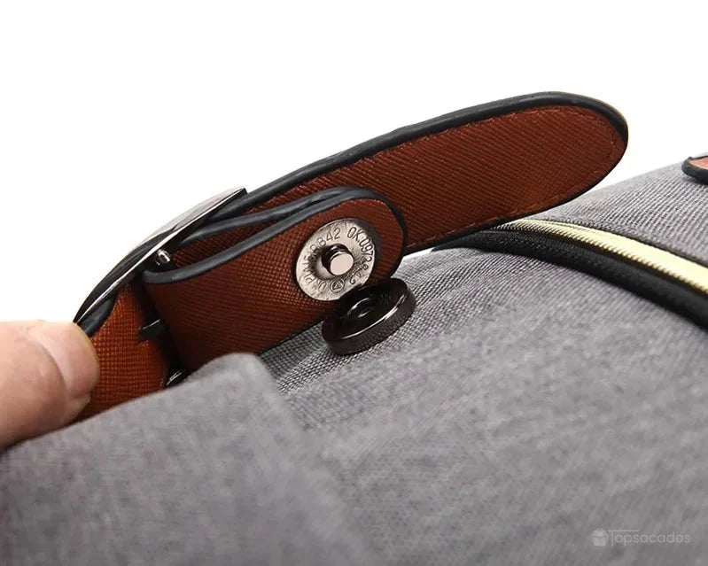 Sac à dos école fille gros plan sur lanières marron et bouton pression métallique