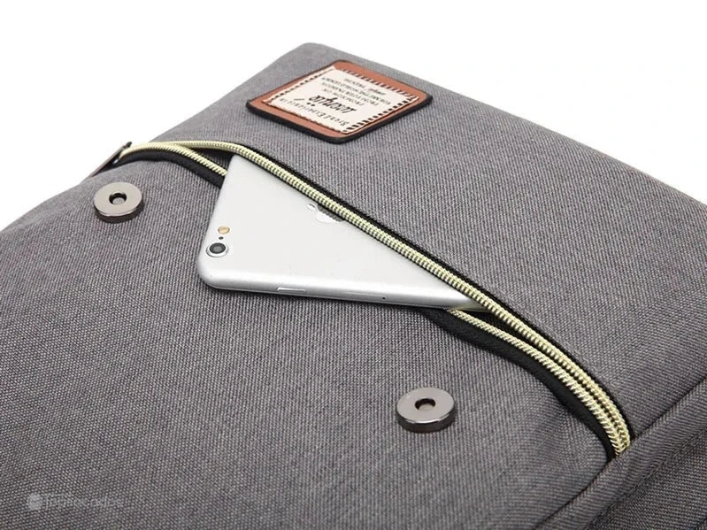 Sac à dos école fille poche frontale zippée contenant un smartphone