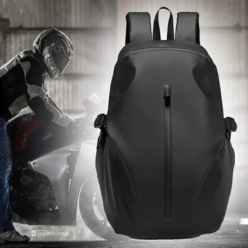 Sac à dos étanche pour moto en situation dans un hangar, mis en valeur à côté d’un motard équipé