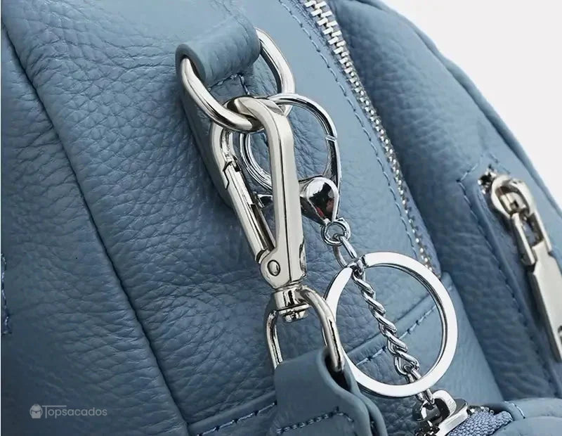 Sac à dos femme chic détail de mousqueton métallique brillant sur cuir bleu, finition soignée
