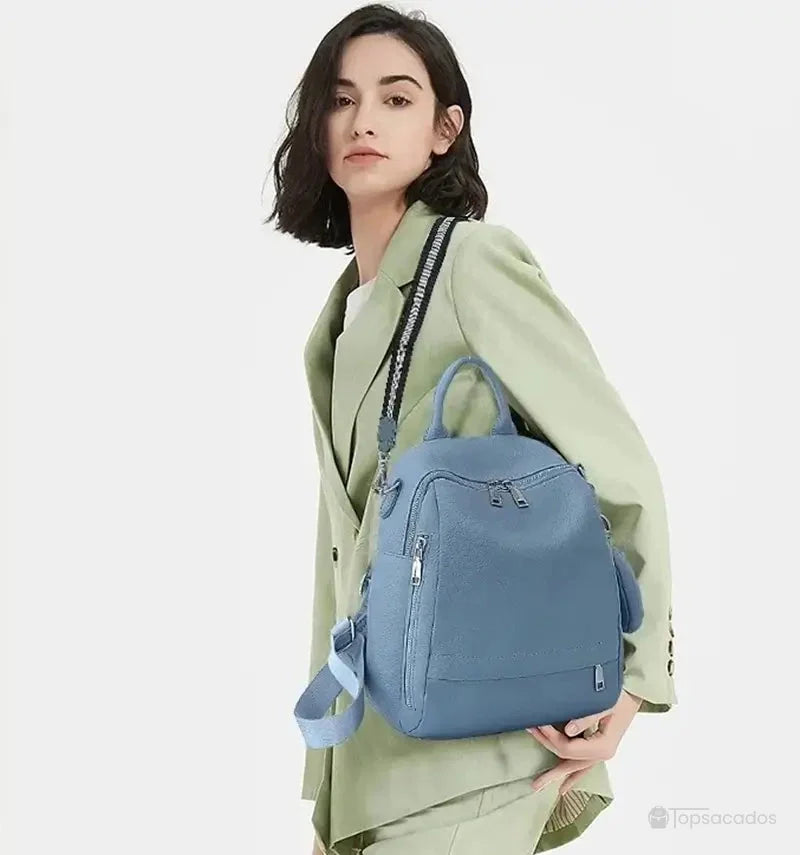 Sac à dos femme chic porté à l’épaule par une femme en tailleur vert clair, allure moderne et élégante