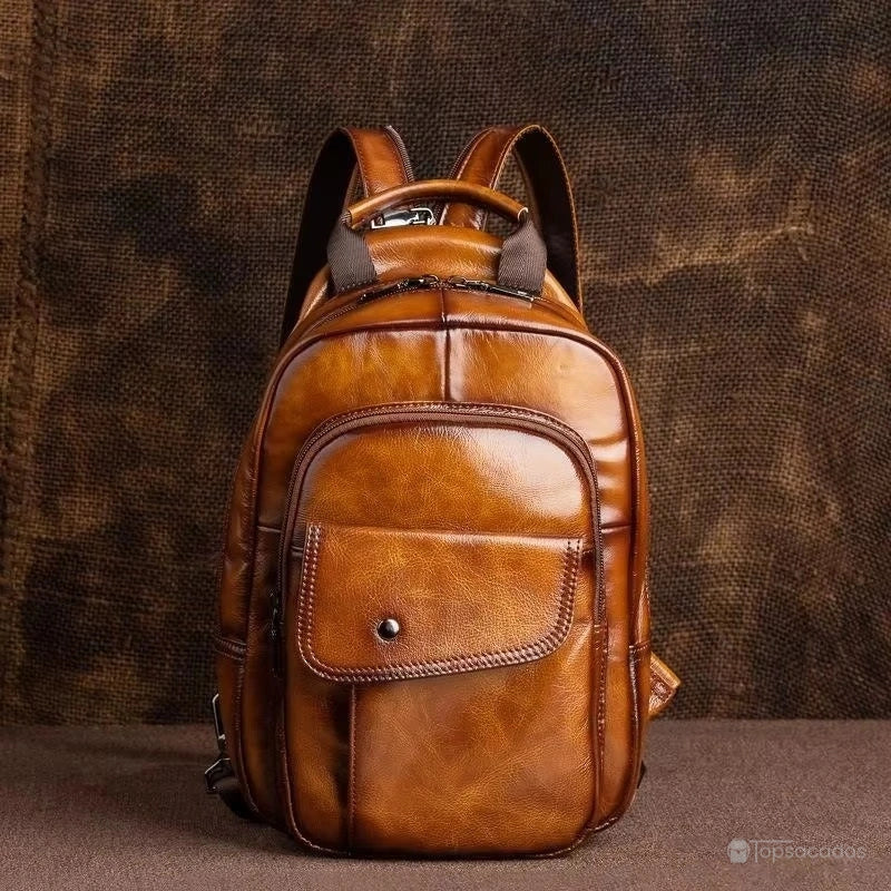 Sac à dos homme cuir de vachette marron foncé exposé sur fond en tissu brut, éclairage chaleureux.