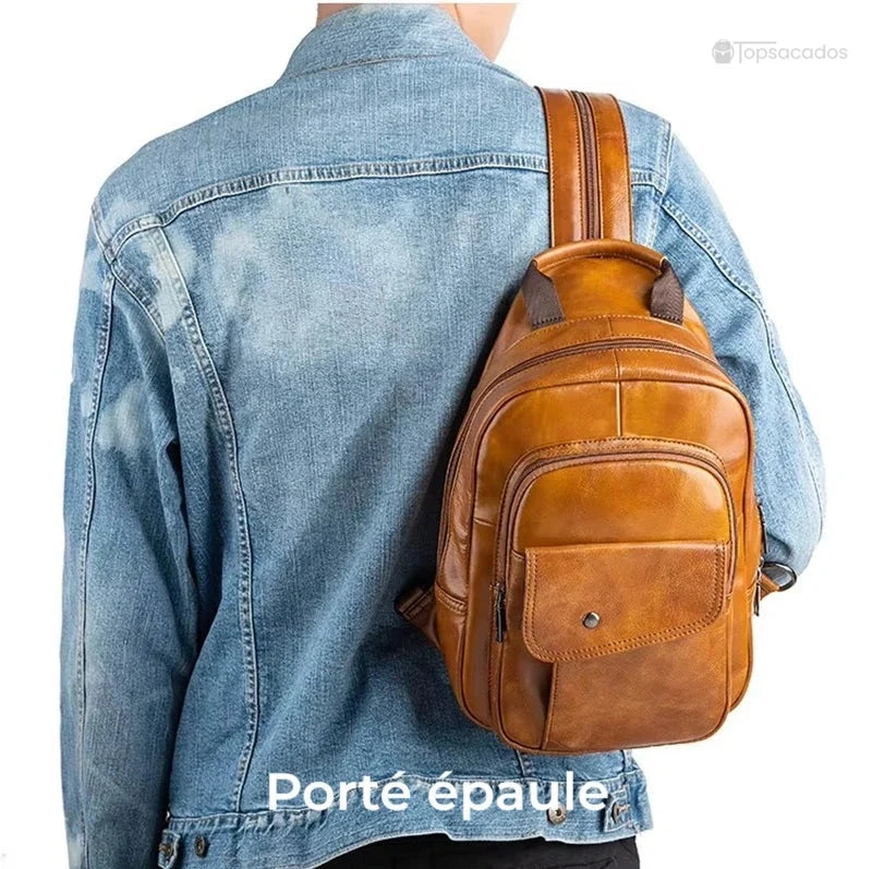 Sac à dos homme cuir de vachette porté à l'épaule sur veste en jean, illustrant un transport pratique et léger, sur fond blanc.