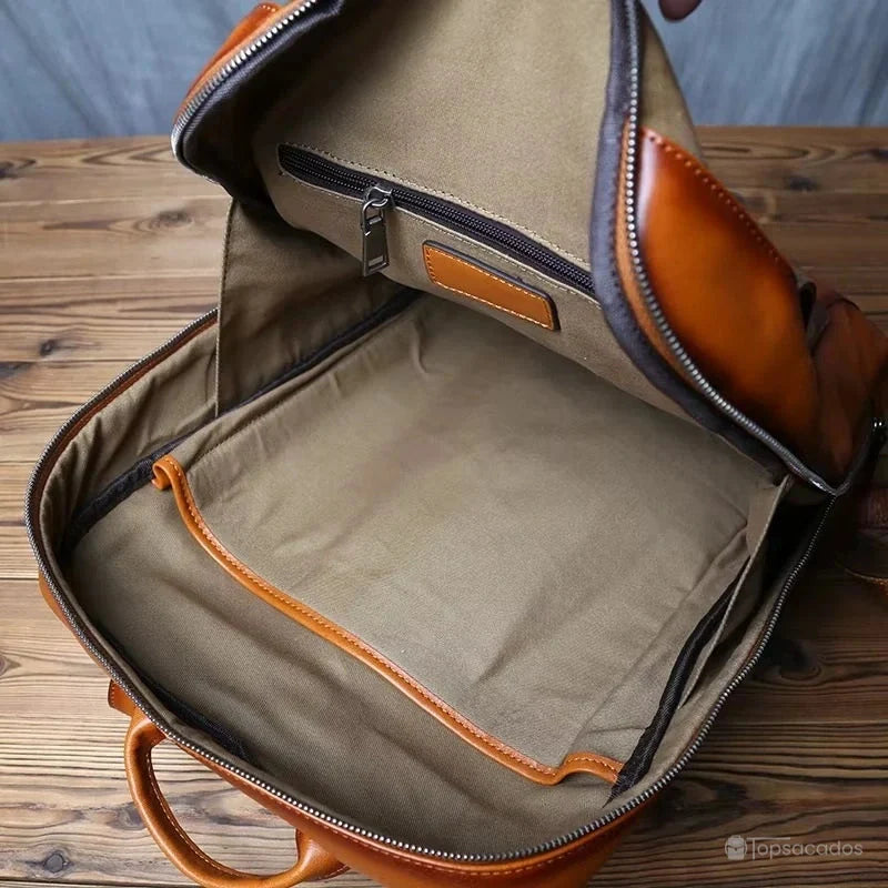 Sac à dos homme cuir marron intérieur vide montrant les poches de rangement en tissu beige, grand espace pour ordinateur et accessoires.