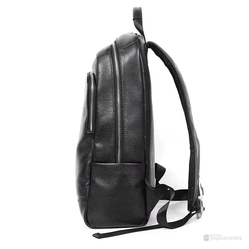 Sac à dos homme cuir - vue latérale montrant la silhouette fine, les deux compartiments à fermeture éclair et une poche latérale.