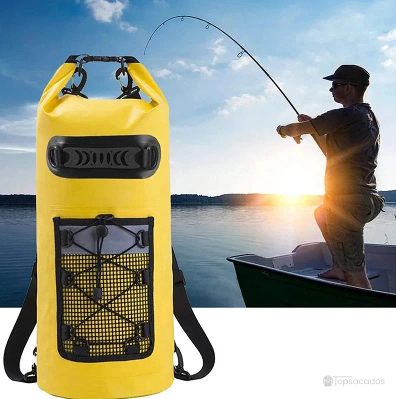 Sac à dos imperméable jaune en premier plan, utilisé par un pêcheur debout sur un bateau au lever du soleil sur un lac calme.
