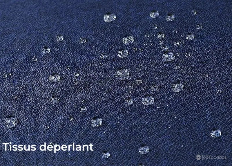 Sac à dos ordinateur Femme tissu bleu marine déperlant avec gouttes d’eau visibles en surface, protection contre l’humidité.