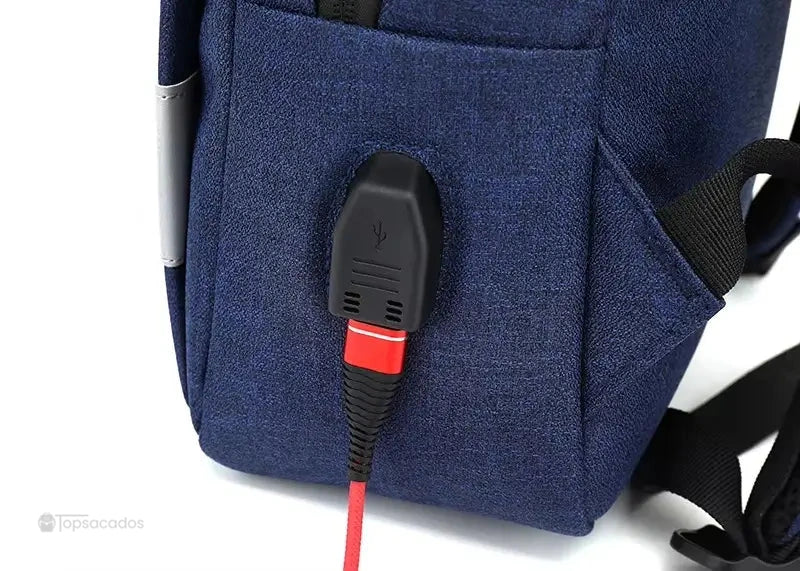 Sac à dos ordinateur Femme avec gros plan sur le port USB intégré, câble rouge branché sur connectique extérieure noire.
