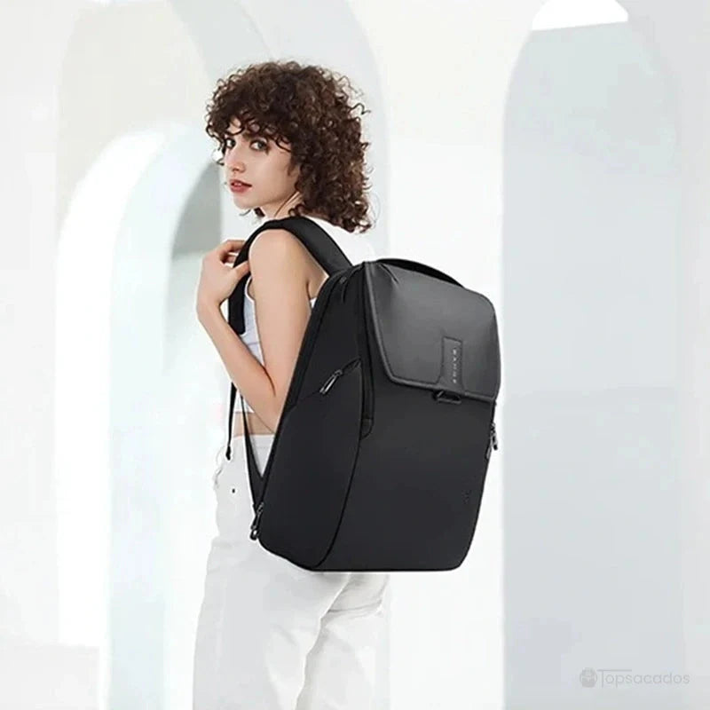 Sac à dos ordinateur portable ouverture par le dessus porté par une femme en intérieur lumineux avec voûtes blanches