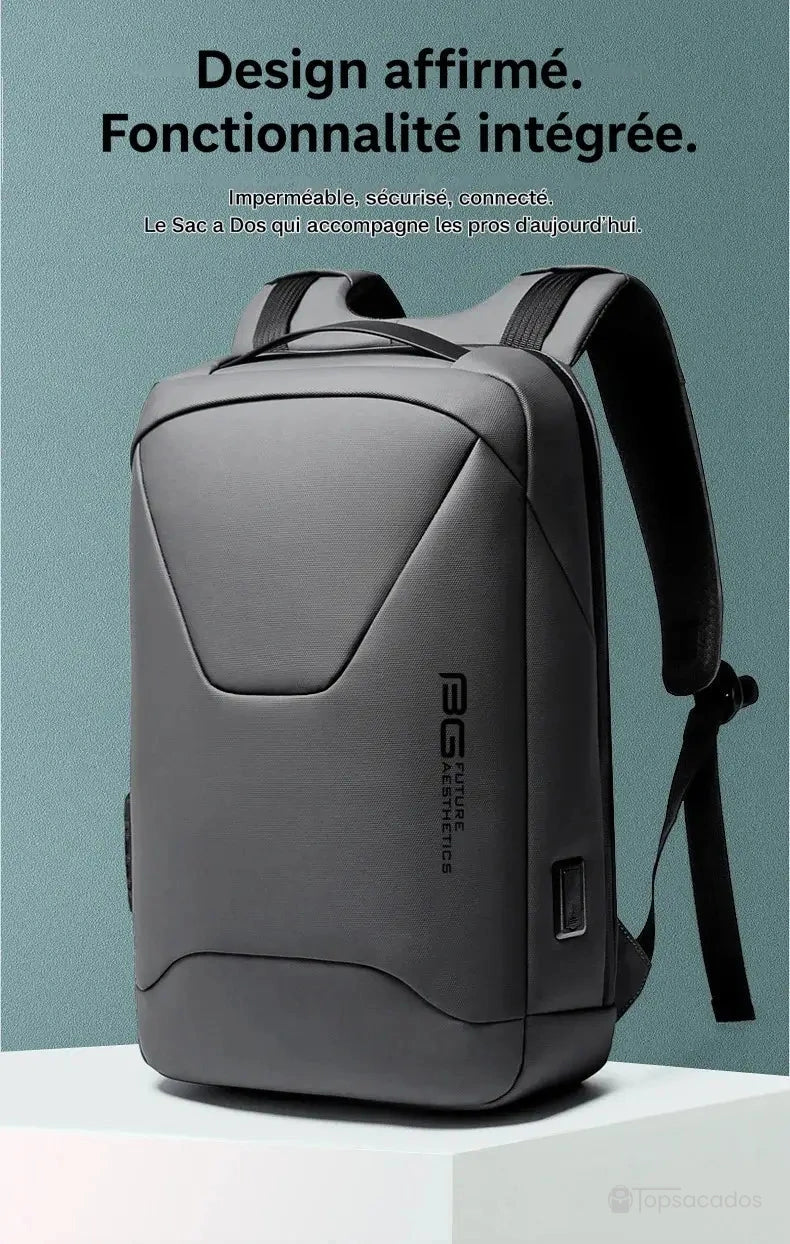 Sac à dos pc portable avec port usb gris foncé au design moderne et lignes affirmées, posé sur un socle clair, fond bleu texturé