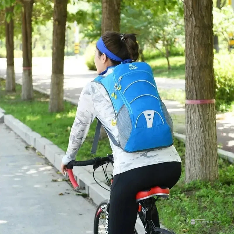 Sac-a-dos-bebe-petite-randonnee porté à vélo par une femme, vue arrière en pleine nature, sécurité et maintien.