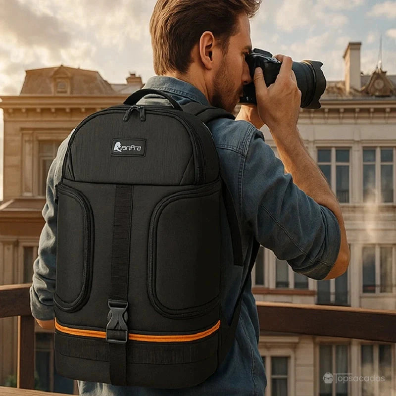 Sac à dos photo porté par un homme en train de photographier en ville, sur fond architectural urbain en fin de journée