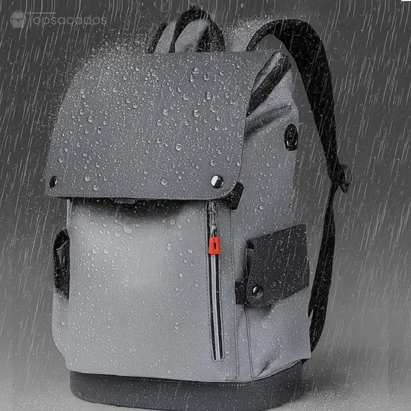 Sac à dos pour étudiant sous la pluie, recouvert de gouttes d’eau illustrant son revêtement imperméable et sa protection contre l’humidité.