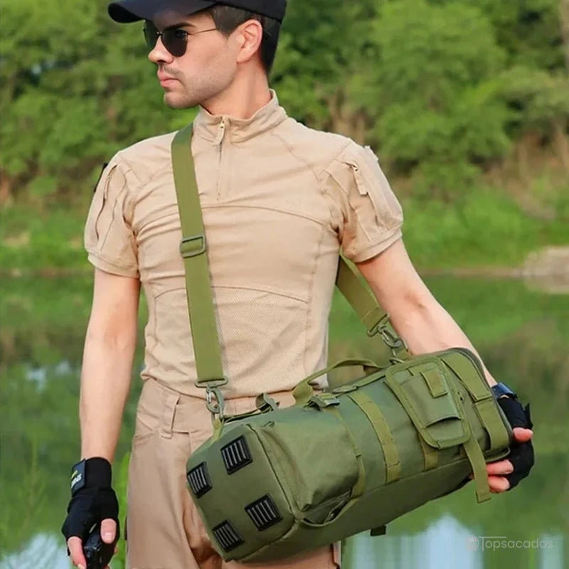 Sac à dos pour la pêche porté à l’épaule par un homme habillé en beige près d’un lac, en position de marche.