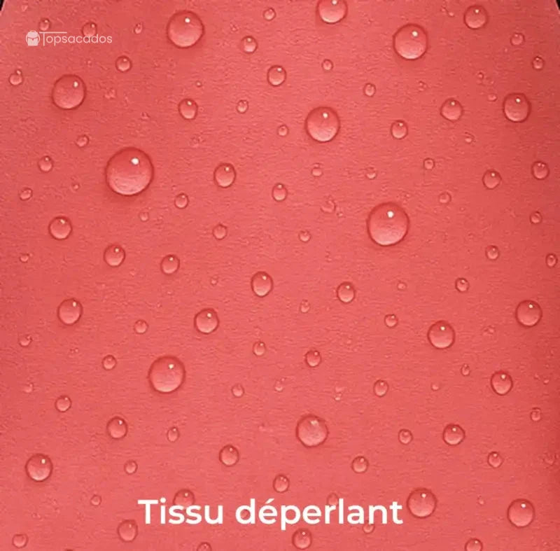 Sac à dos pour lycéen gros plan sur tissu déperlant rose avec gouttes d’eau visibles sur la surface.