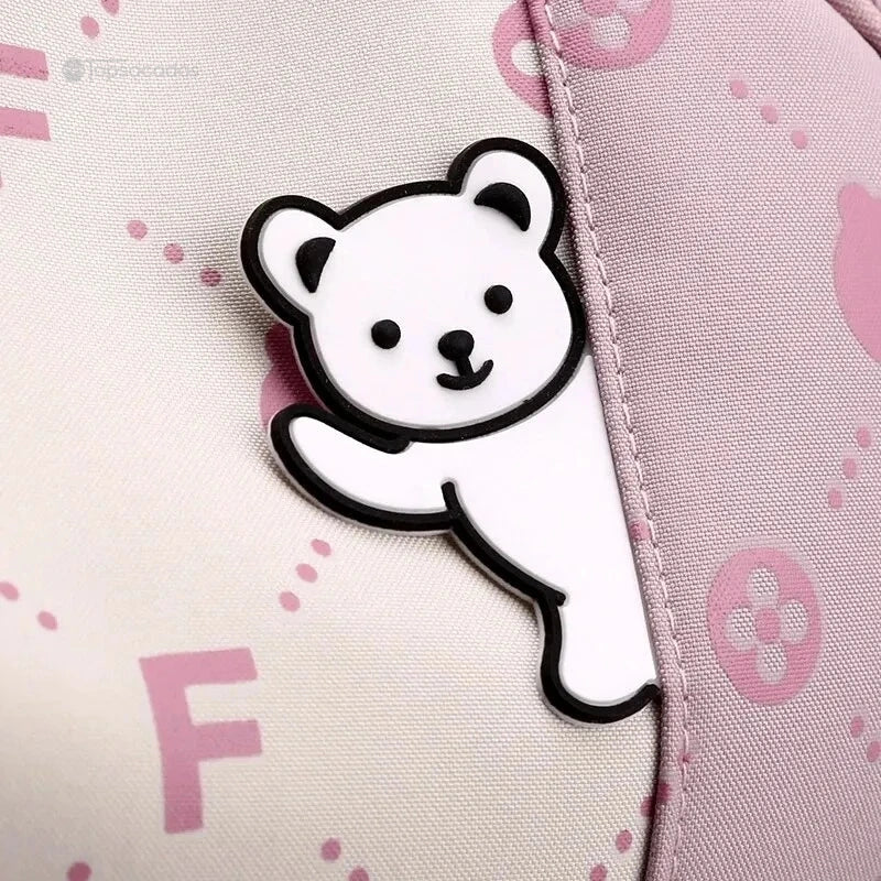 Sac à dos primaire fille avec décoration en forme d'ours blanc sur fond rose clair.