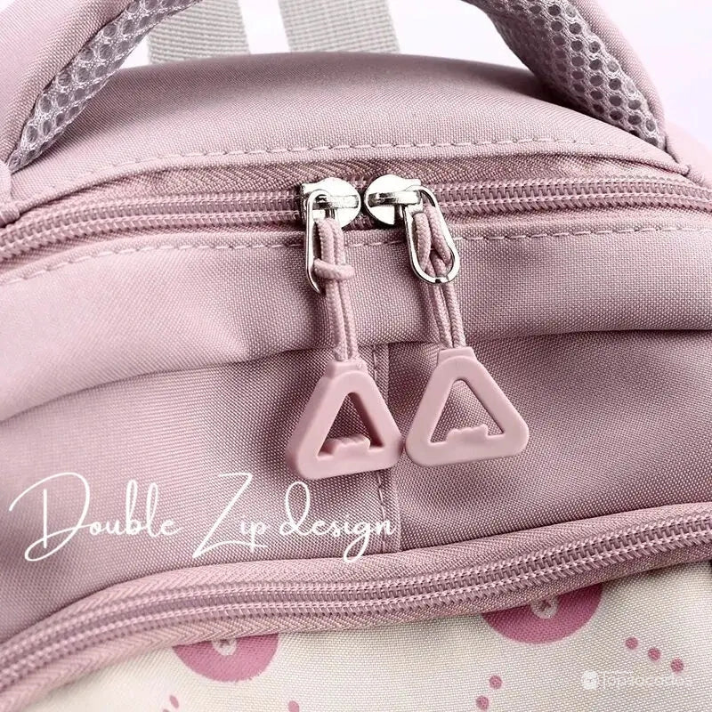 Sac à dos primaire fille avec gros plan sur double fermeture éclair à tirettes triangulaires.