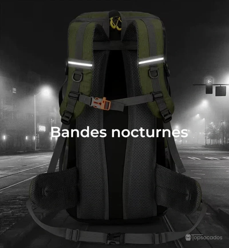Sac à dos randonnée 50 litres vu de dos en environnement urbain nocturne, avec bandes réfléchissantes pour visibilité de nuit.