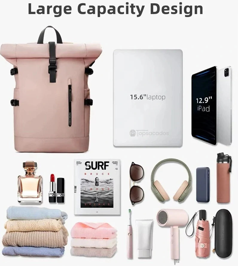 Sac a dos Roll Top pour femme rose présenté avec son contenu possible : vêtements, tablette, chargeur, livres et accessoires, illustrant sa grande capacité de rangement.