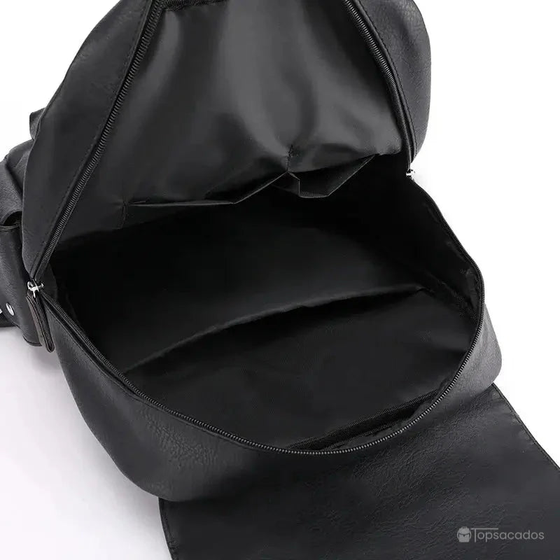 Sac à dos simili cuir noir avec compartiment intérieur vide et doublure textile noire, illustrant la capacité de rangement.