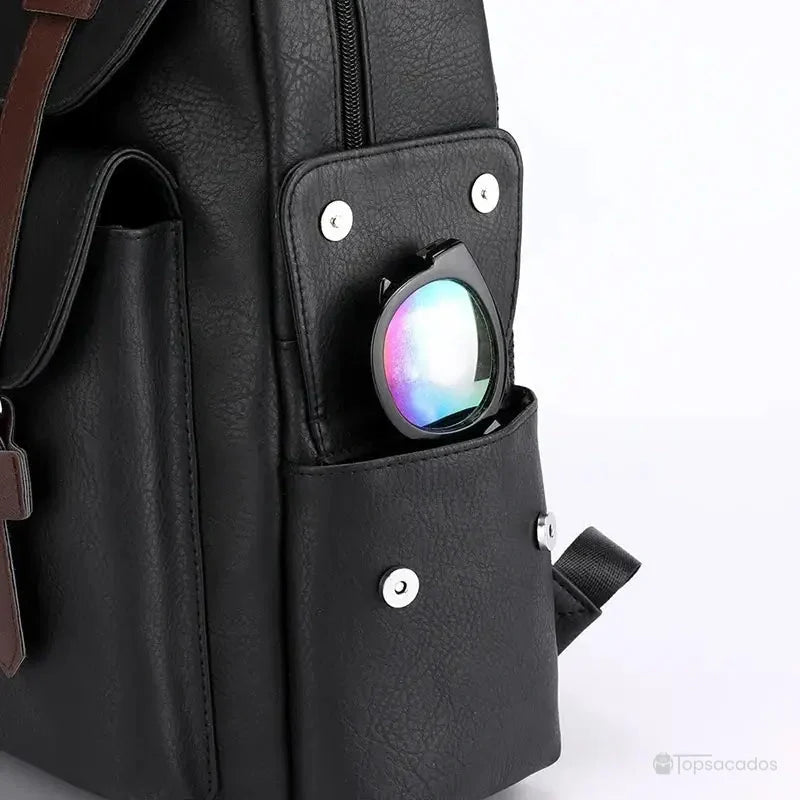 Sac à dos simili cuir noir avec focus sur la poche latérale contenant une paire de lunettes de soleil à reflets.