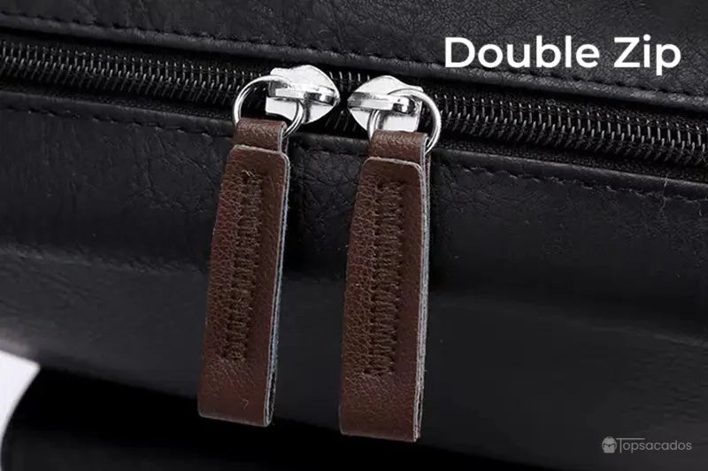 Sac à dos simili cuir noir avec zoom sur la fermeture éclair double curseur ornée de languettes marron.