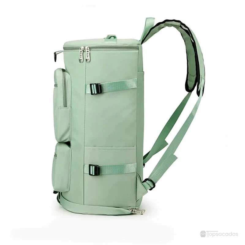 Sac à dos sport grand volume vu de profil, couleur vert pastel, avec bretelles épaisses, poches latérales et sangles de compression.