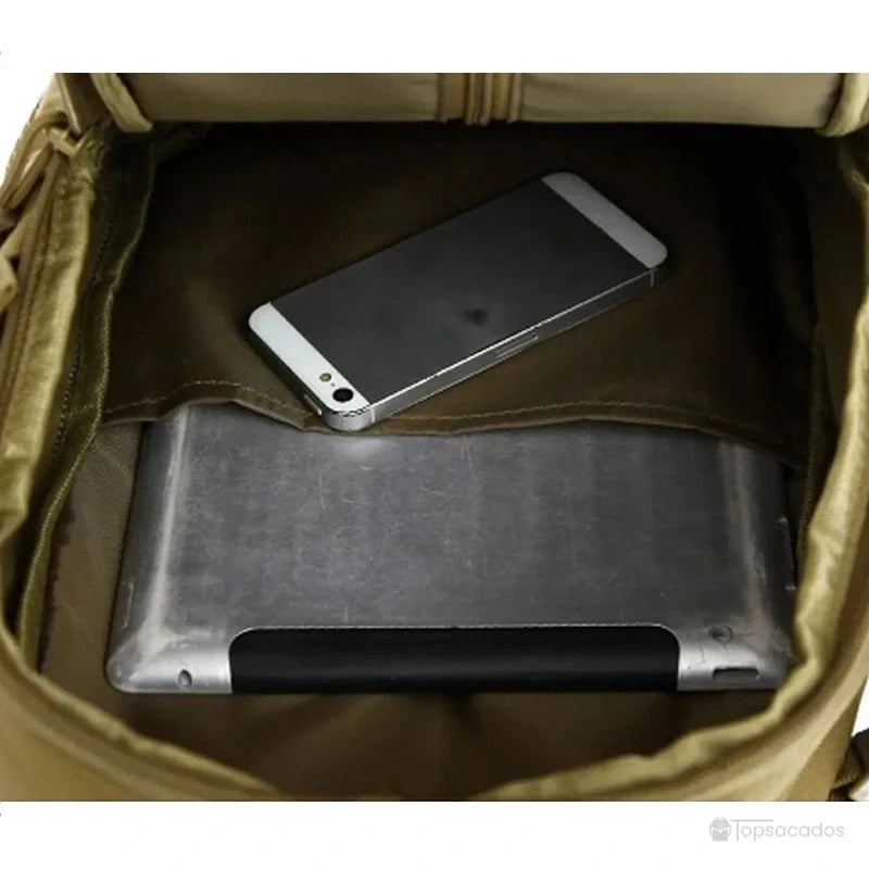 Sac à dos style militaire Femme ouvert avec tablette et smartphone rangés dans la poche principale.