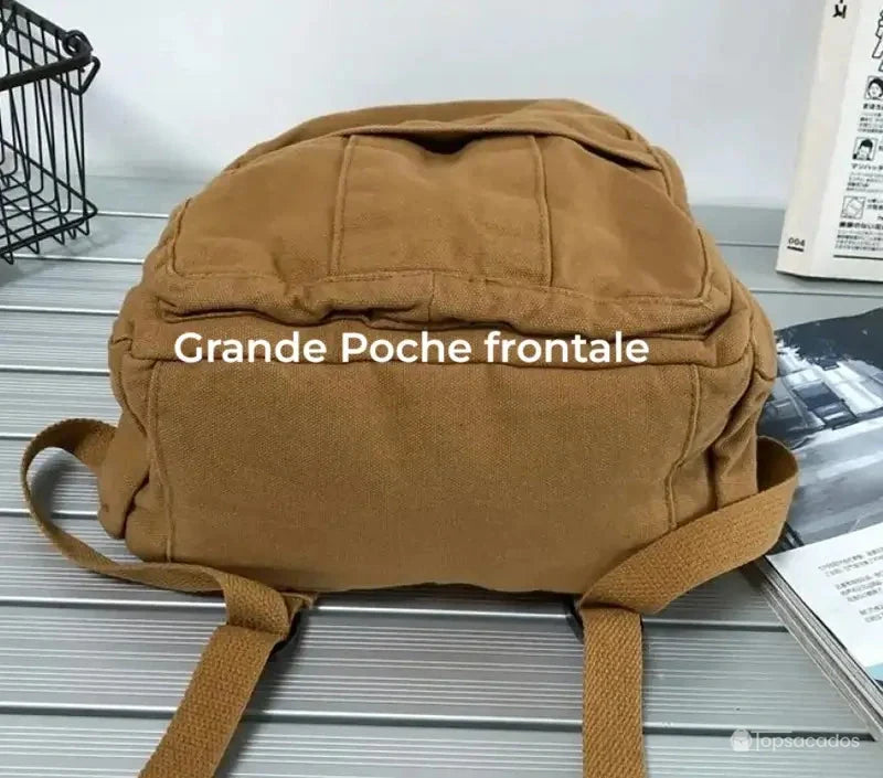 Sac à dos toile marron posé à plat montrant une grande poche frontale zippée