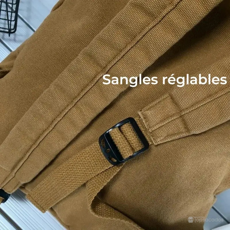 Sac à dos toile marron avec sangles réglables en gros plan sur une surface en bois