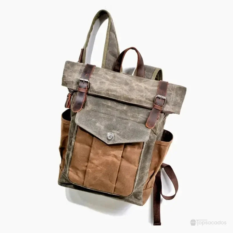 Sac à dos toile homme vintage suspendu par les bretelles, en position inclinée pour en montrer la structure robuste.