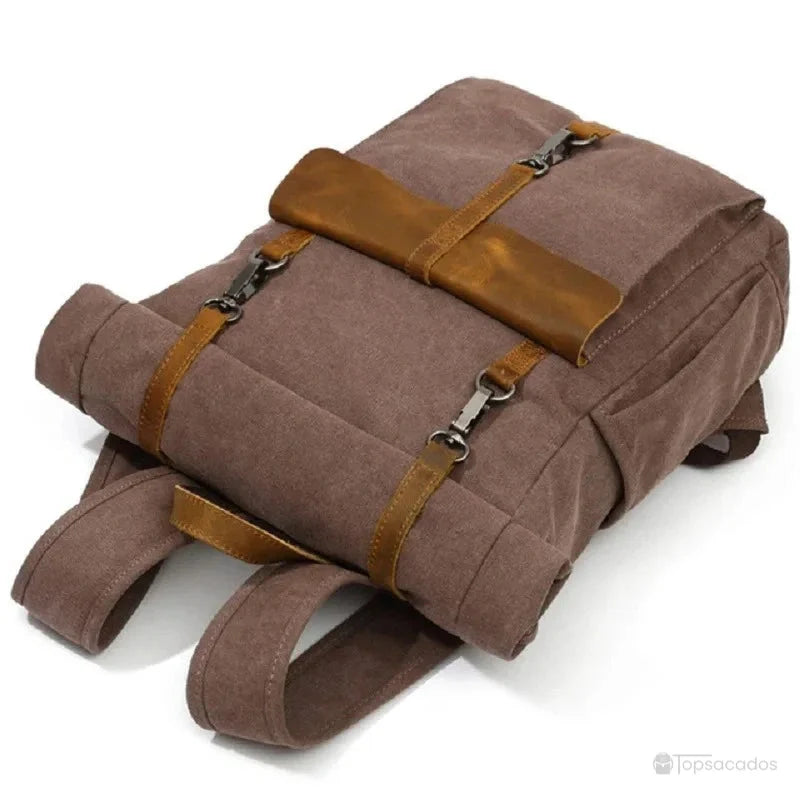 Sac à dos toile Rolltop vu allongé à plat, mettant en valeur les attaches en métal robustes et la texture canvas, idéal pour transporter en sécurité.