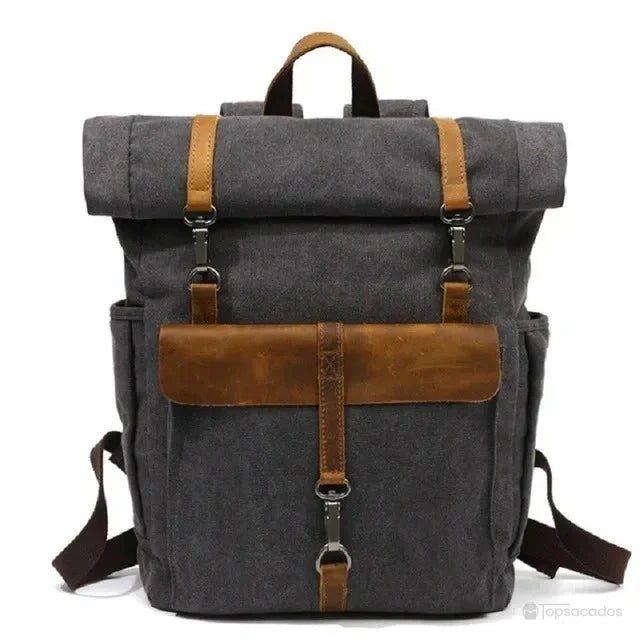 Sac à dos toile Rolltop gris foncé avec poches latérales et rabat cuir, conçu pour les trajets quotidiens avec un look vintage affirmé.