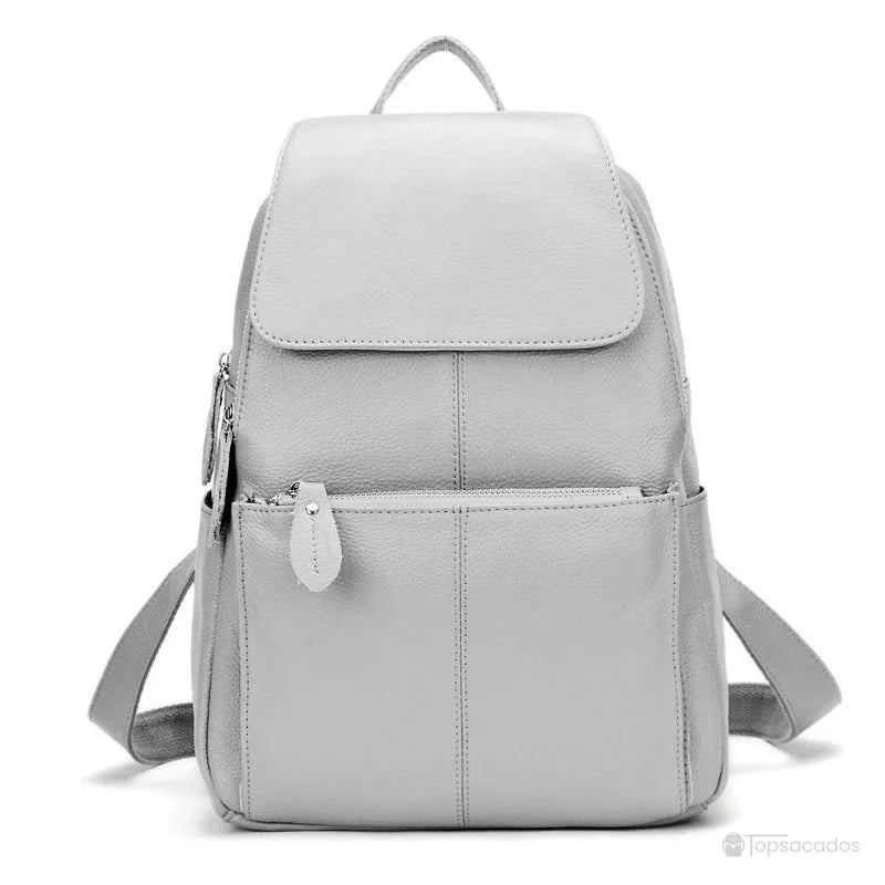 sac à dos ville femme gris clair en cuir lisse, avec fermeture à rabat et poches latérales visibles sur fond blanc